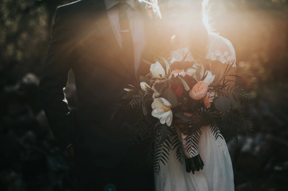 sposo accanto alla sposa che tiene un mazzo di fiori